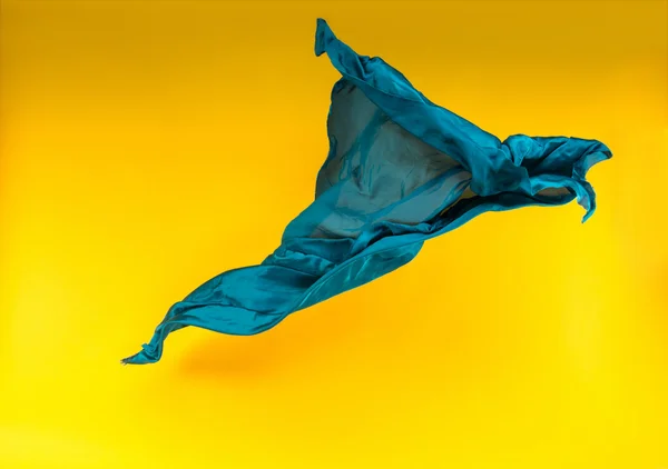 Tecido azul sobre fundo amarelo — Fotografia de Stock