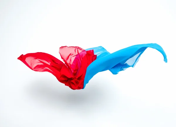 Abstract pieces of blue and red fabric flying — Stock Photo, Image