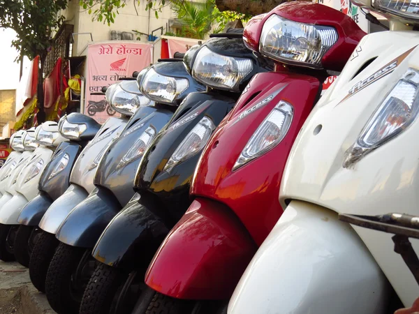 Скутеры Suzuki продаются рядом с магазином Honda в Индии — стоковое фото