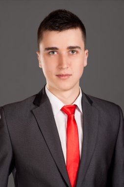 gri arka plan üzerinde duran genç işadamı