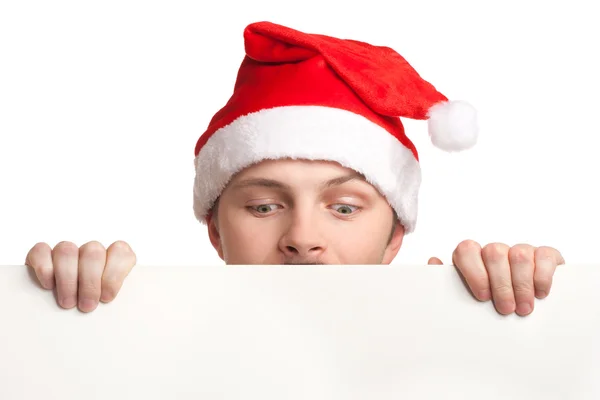 Junger Mann mit Weihnachtsmannmütze mit einem leeren Schild — Stockfoto