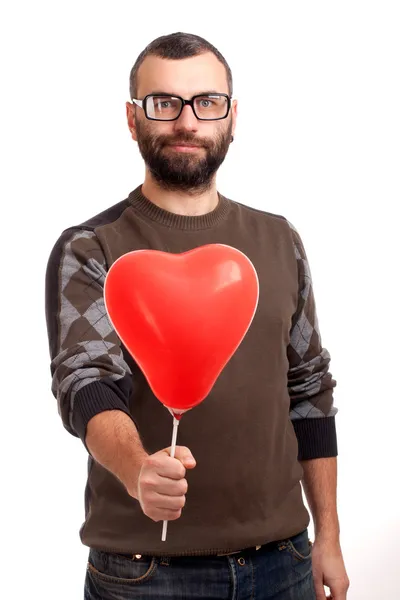 Handsome young man with beard holding red balloon — Stock Photo, Image