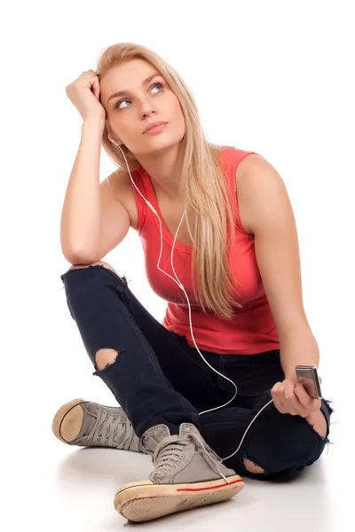 ブロンドの 10 代の少女の座っていると耳を傾けるの音楽 — ストック写真