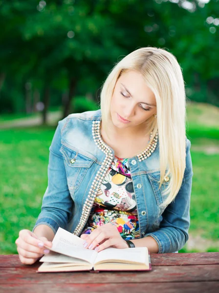 Bela jovem com livro no parque — Fotografia de Stock