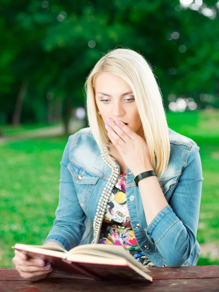 Bela jovem com livro no parque — Fotografia de Stock