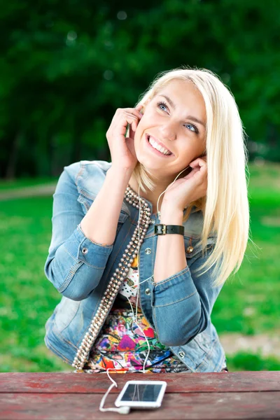 Young blond girl listening player — Stock Photo, Image