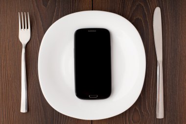 Beyaz bir plaka üzerinde cep telefonu
