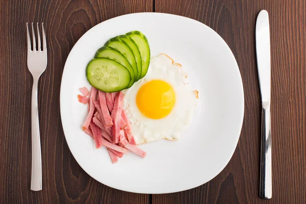 Fried egg with ham and cucumber — Stock Photo, Image