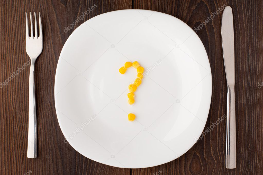 Question mark made of corn seeds on plate
