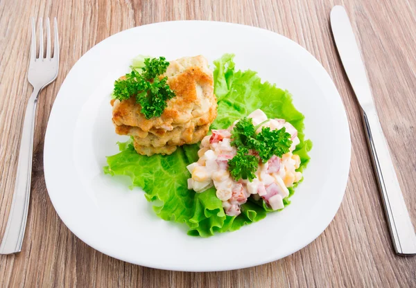 Hühnerschnitzel mit Salat auf dem Teller — Stockfoto