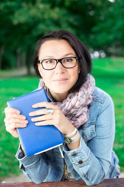 Bela jovem com livro no parque — Fotografia de Stock