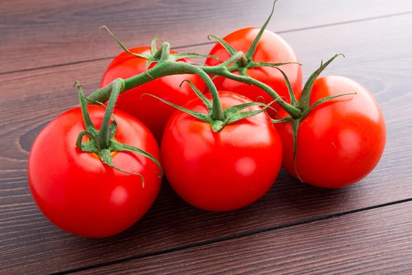 Manojo de tomates sobre mesa de madera — Foto de Stock