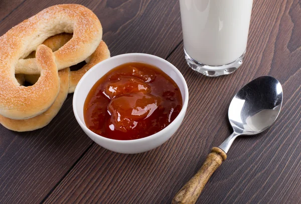 Zachte pretzels, Abrikozenjam en glas melk — Stockfoto