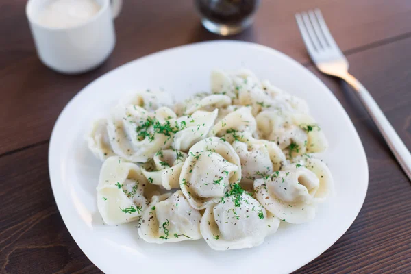 Fresh boiled meat dumplings served with dill — Stock Photo, Image