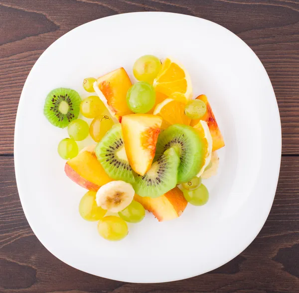 Assortiment de fruits tranchés sur assiette — Photo