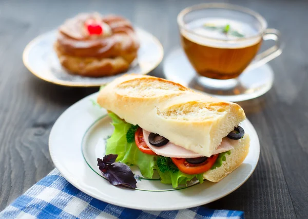 Frühstück mit Sandwich, Tee und Kuchen — Stockfoto