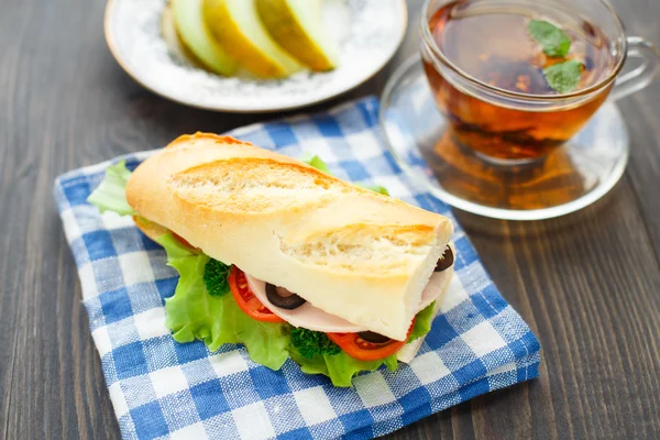 Breakfast with sandwich, tea and melon — Stock Photo, Image