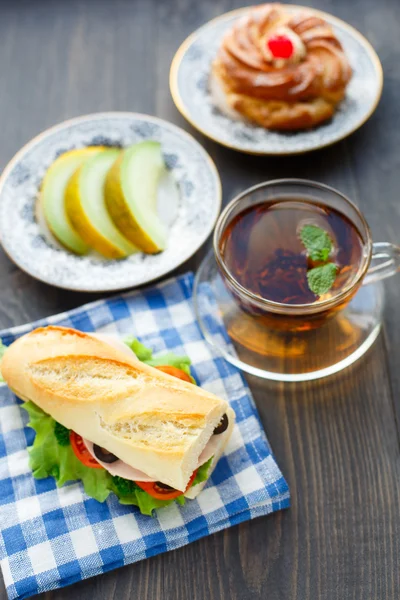 Café da manhã com sanduíche, chá, bolo e melão — Fotografia de Stock