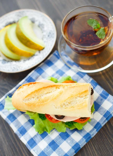 朝食のサンドイッチ、紅茶とメロン — ストック写真