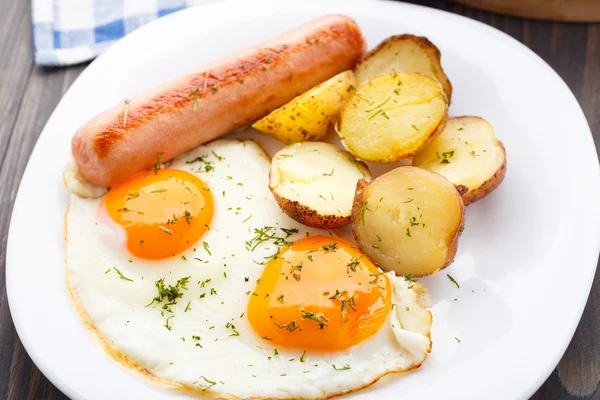 Petit déjeuner avec œufs, saucisses et pommes de terre — Photo