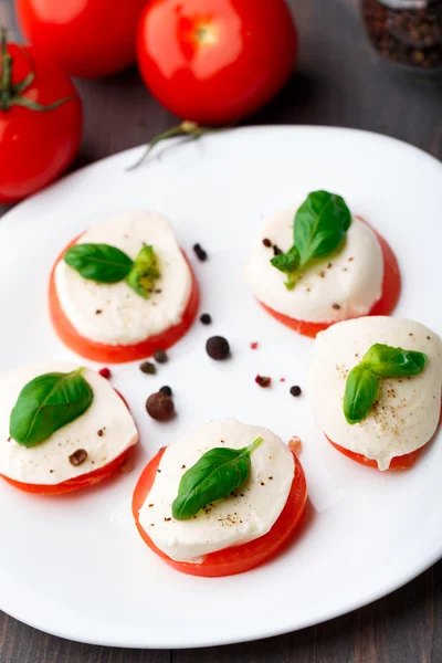 Tomato and mozzarella with basil leaves — Stock Photo, Image