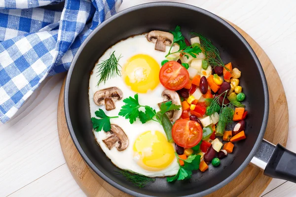 Gebakken eieren in een pan met groenten — Stockfoto