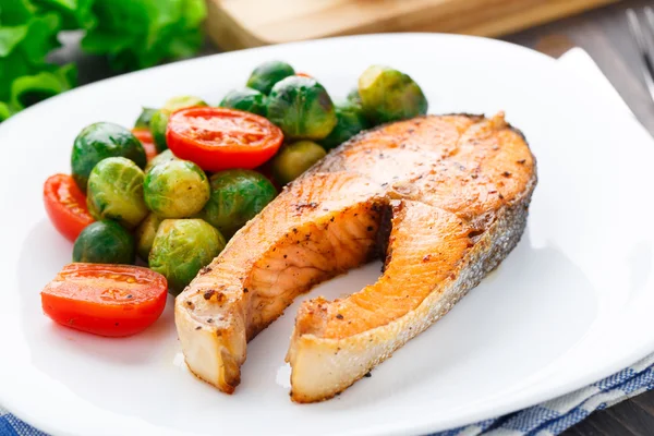 Zalm met geroosterde Brussel stronk en tomaat — Stockfoto