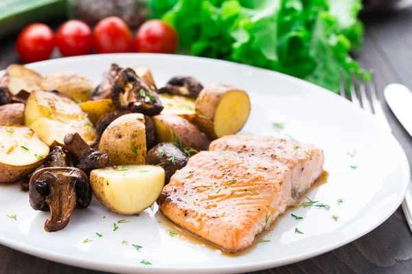 Roasted salmon with potatoes and mushrooms Royalty Free Stock Photos