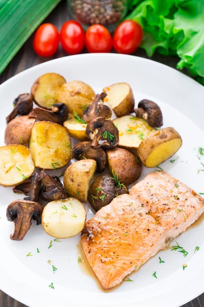 Roasted salmon with potatoes and mushrooms Royalty Free Stock Photos