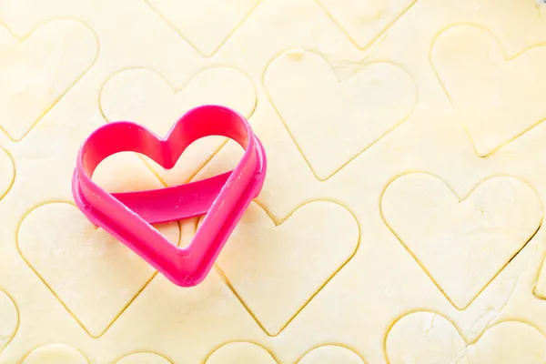 Cortador de biscoito em forma de coração na massa crua — Fotografia de Stock