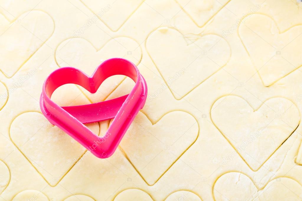 Heart shaped cookie cutter on raw dough