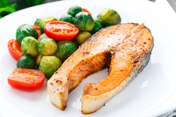 Salmón con coles de Bruselas asadas y tomate — Foto de Stock