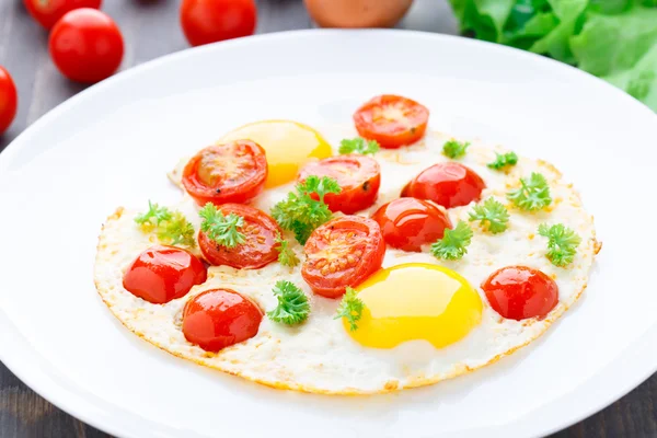 Fried eggs with cherry tomatoes — Stock Photo, Image