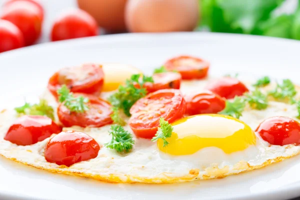 Fried eggs with cherry tomatoes — Stock Photo, Image