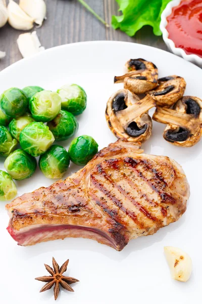 Chuleta de cerdo a la parrilla con coles de Bruselas — Foto de Stock