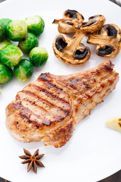 Chuleta de cerdo a la parrilla con coles de Bruselas —  Fotos de Stock