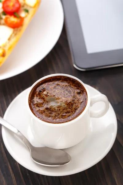Kopje koffie, broodje en Tablet PC — Stockfoto