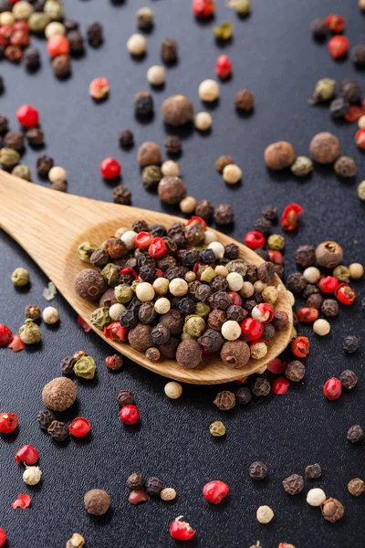 Mixed peppers on a wooden spoon — Stock Photo, Image