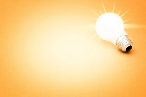 Background with lit lightbulb — Stock Photo, Image