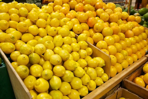 Holzbehälter gefüllt mit frischen Zitronen und Orangen lizenzfreie Stockfotos