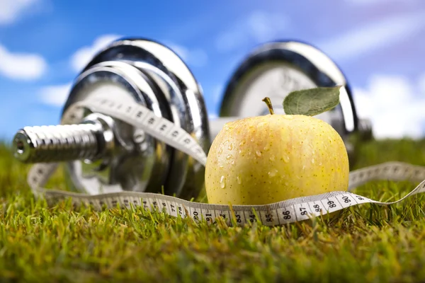 Dieta de Vitamina y Fitness, dumbell en hierba verde — Foto de Stock