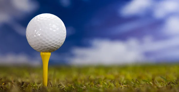 Golf ball on green grass over a blue sky — Stock Photo, Image