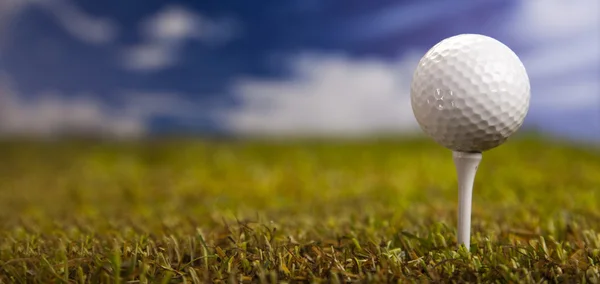 Bola de golfe na grama verde sobre um céu azul — Fotografia de Stock