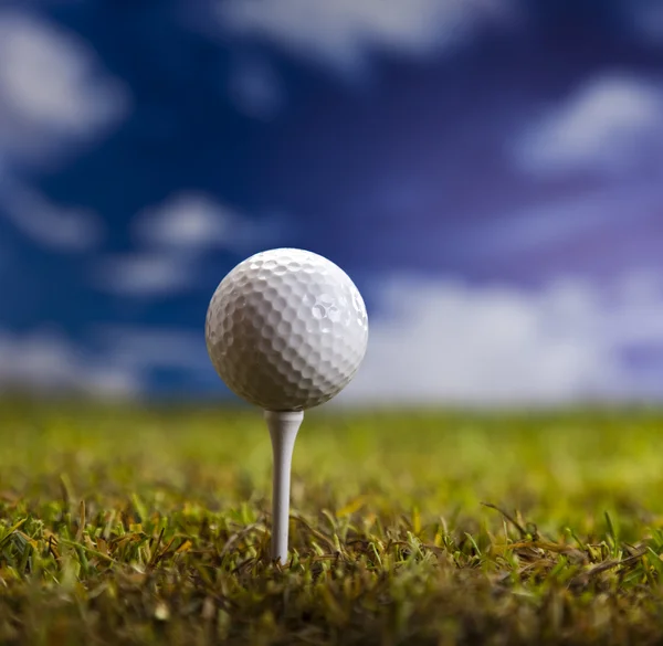 Bola de golfe na grama verde sobre um céu azul — Fotografia de Stock