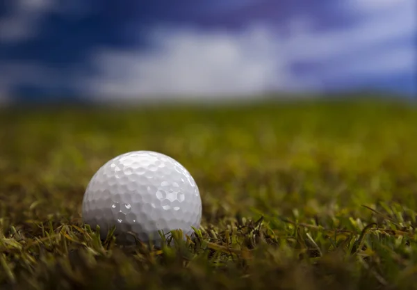 Golfový míček na zelené trávě nad modrá obloha — Stock fotografie