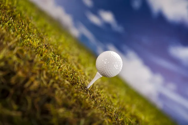 Golfboll på grönt gräs under en blå himmel — Stockfoto