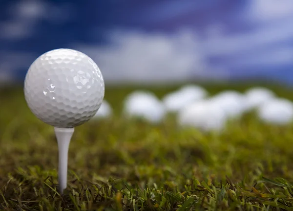 Bola de golfe na grama verde sobre um céu azul — Fotografia de Stock