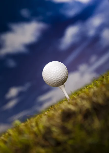 Мяч для гольфа на зеленой траве над голубым небом — стоковое фото