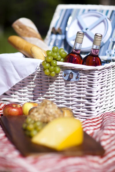 Wijn en picknick mand op het gras — Stockfoto