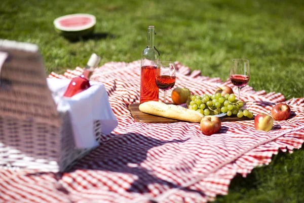 Wijn en picknick mand op het gras — Stockfoto